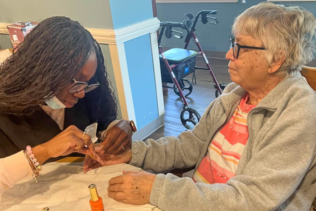 A Nail Tech student from SGTC works with a resident at Magnolia Manor.