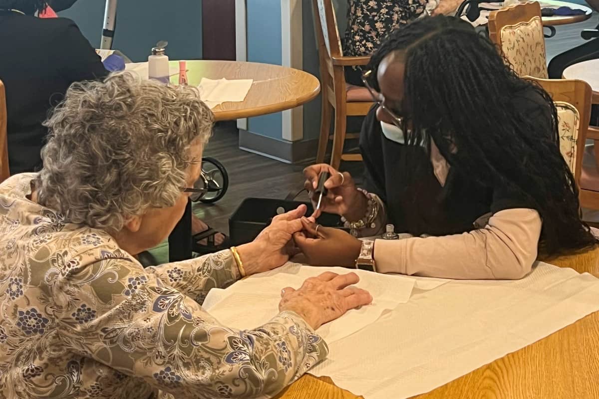 A Nail Tech student from SGTC works with a resident at Magnolia Manor.