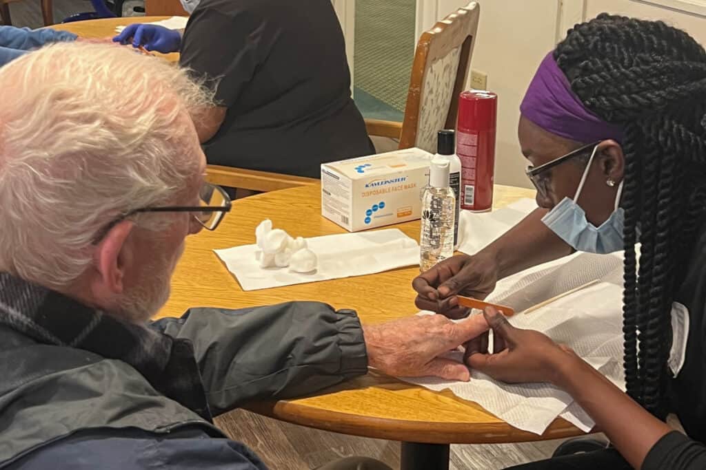 A Nail Tech student from SGTC works with a resident at Magnolia Manor.