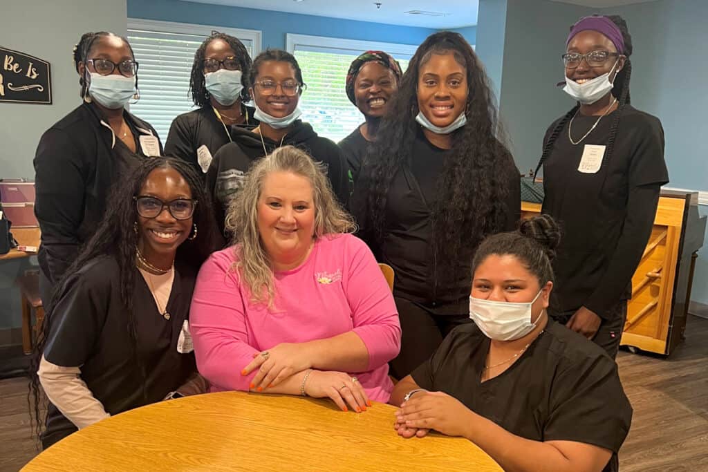SGTC Nail Tech instructor Jessakeetha Maddox (standing second from right) and students are pictured here with Billie Jo Etheridge of Magnolia Manor (seated center) during a recent trip to provide nail services to manor residents.