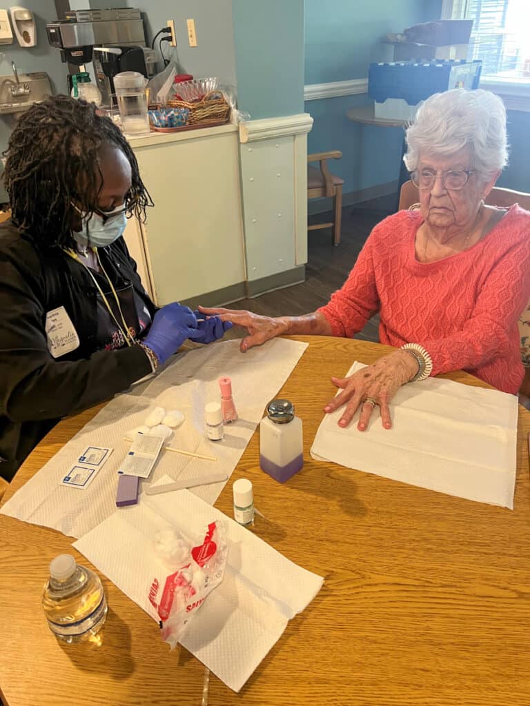 A Nail Tech student from SGTC works with a resident at Magnolia Manor.
