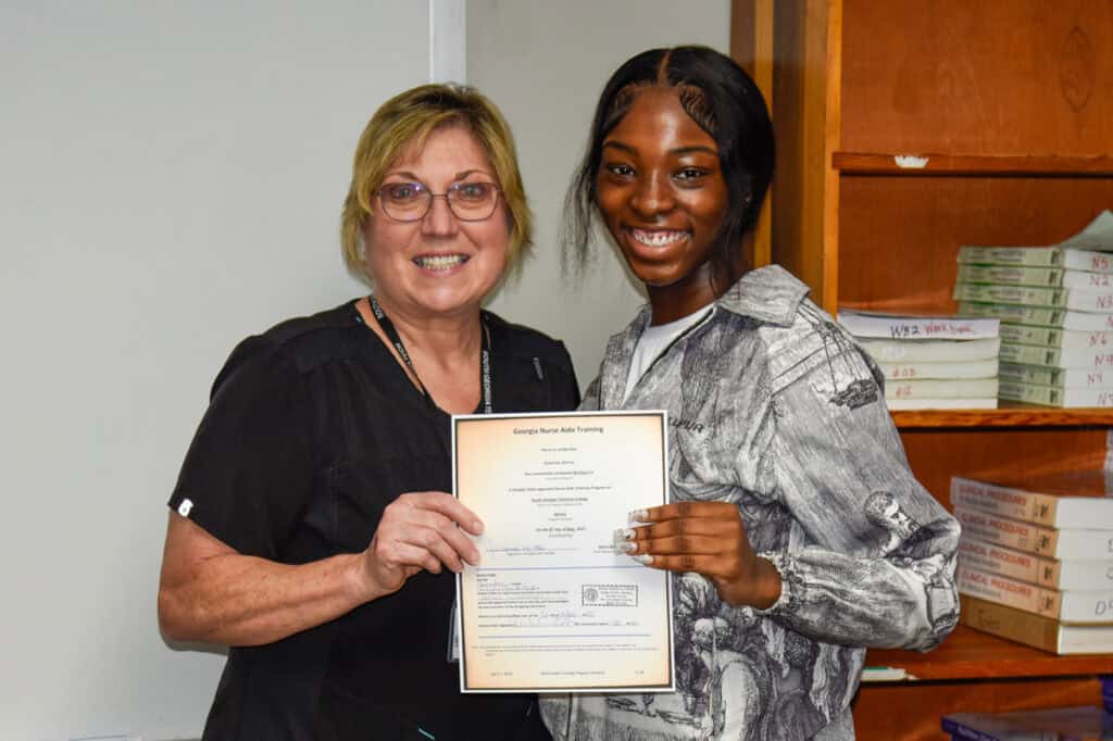 Instructor Janice Wiseman presents certificate to student