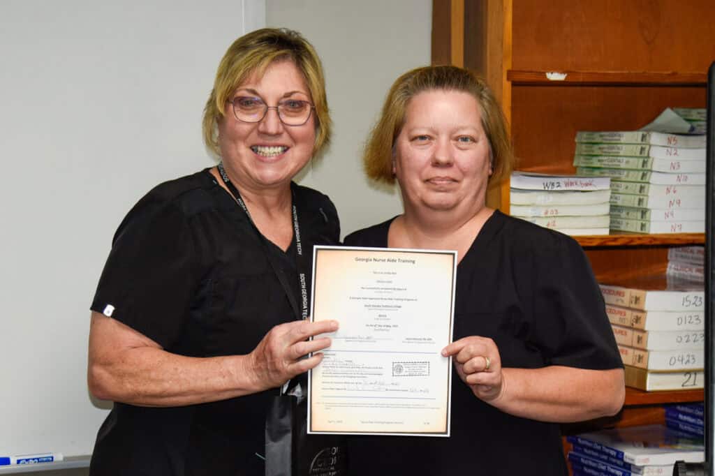 Instructor Janice Wiseman presents certificate to student
