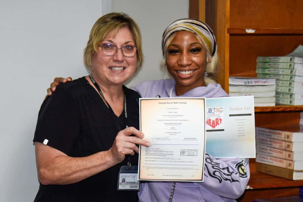 Instructor Janice Wiseman presents certificate to student
