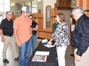 Tami Blount is shown above with several students signing in while John Deere Tech Dean Dr. David Finley look on.