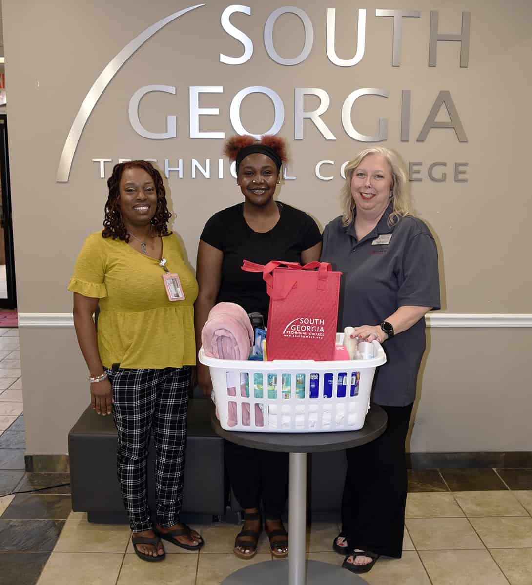 SGTC Special Services Coordinator Jennifer Robinson (left) and Criminal Justice instructor Teresa McCook (right) present a gift basket to Paris Simpson for being first to complete the SGTC QEP course for summer semester.