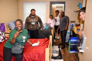 A student and family set up a dorm room.