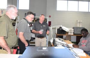 SGTC Electronics Instructor Mike Collins gives Sidney Smith and Bruce Barnes a tour of the Electronics lab and classroom.