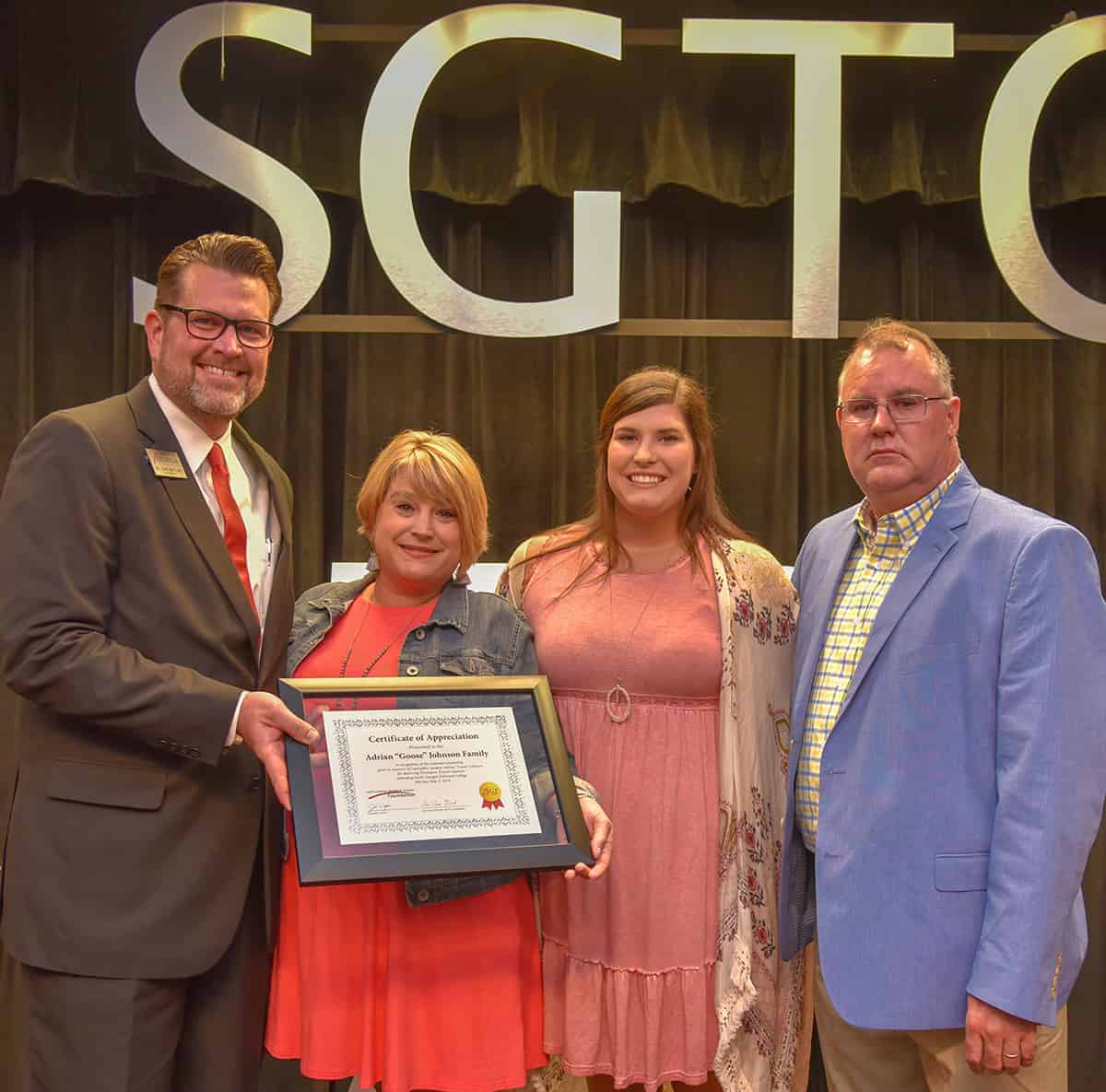 South Georgia Technical College President Dr. John Watford is shown above presenting the framed certificate for the endowed Adrian “Goose” Johnson CAT Thompson Tractor scholarship to Amber, Sarah, and Kelly Johnson at the 2019 CAT Dealer Graduation Dinner. Today the “Fly High Goose” Foundation and Thompson Foundation are continuing to support the endowed scholarship through additional donations.