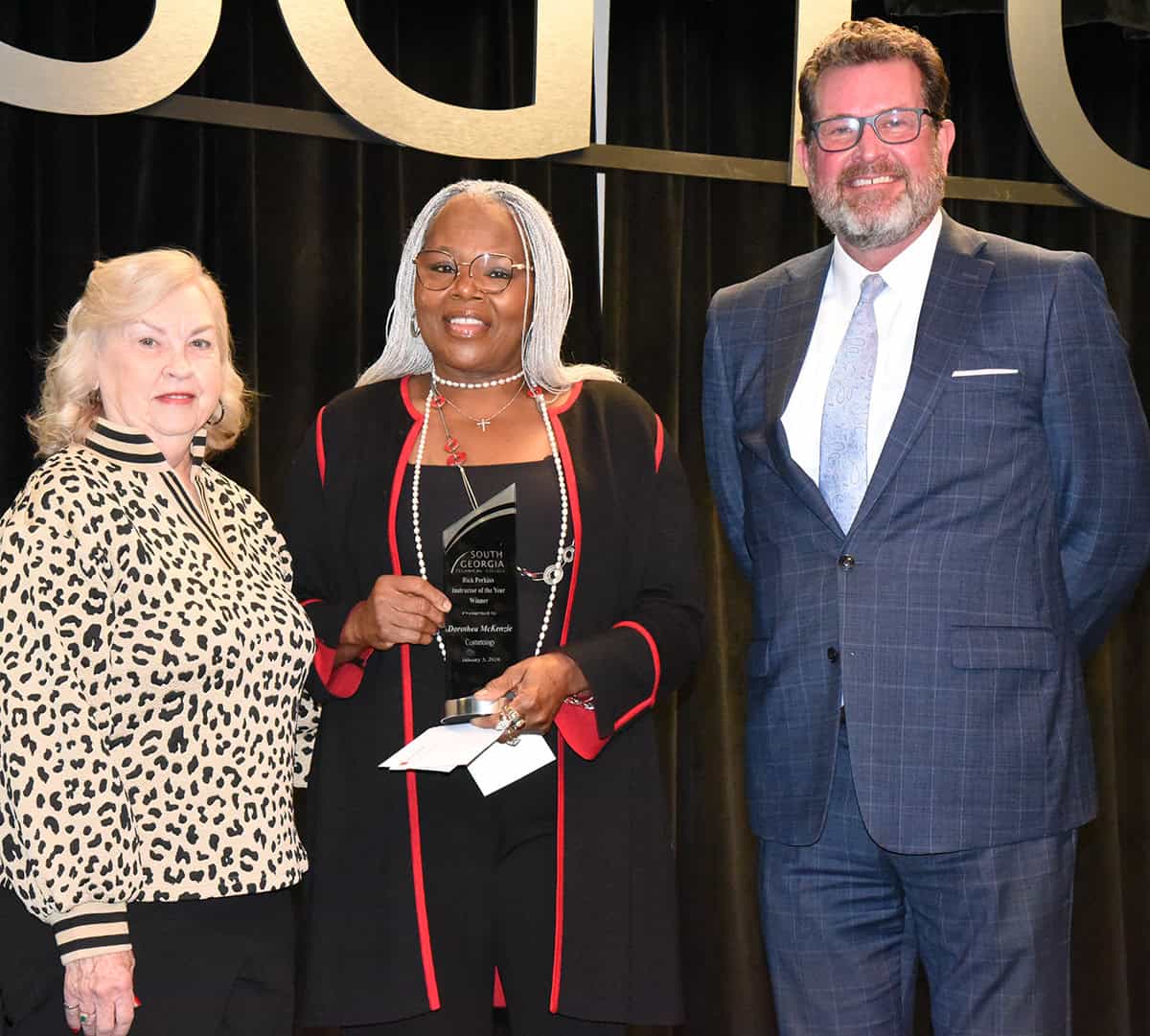 Allene Reeves (left) is shown above presenting Dorothea Lusane McKenize (center) with a check for being named the SGTC 2026 Instructor of the Year. SGTC President Dr. John Watford is also shown (right) congratulating McKenzie.