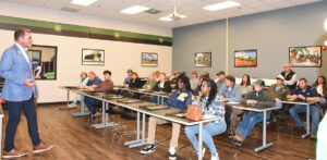 Dr. Watford is talking with John Deere Ag Tech prospective students and parents.